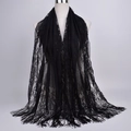 Close-up of black floral lace scarf featuring intricate cutouts and long fringe tassels - 180cmx60cm / Black