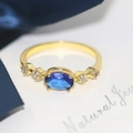 Vintage gold ring featuring an oval blue gemstone with cubic zirconia side stones - US 7 / 14K Light Gold Blue Zircon