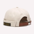 Dettaglio del berretto docker in cotone beige con cinturino in pelle marrone regolabile - Regolabile / Beige
