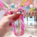 Detail of child hair tie with colorful synthetic braids and a glittery rainbow bow - Rainbow 1