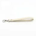 Detail of cream crossgrain PU leather wristlet strap with silver lobster clasp and neat stitching - Off White