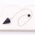 Dettaglio macro della collana pendolo in pietra blu su un piatto di ceramica - Pietra Conica + Catena Argentata / Pietra di sabbia blu