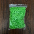 Bulk pack of green plastic stitch markers for knitting on dark wood background - Green
