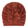 Detail of baby turban hat featuring a large handmade fabric flower in terracotta cotton - Rust red