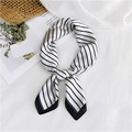 Elegant black and white striped silk scarf tied in a bow on a woven beach bag backdrop - Striped White