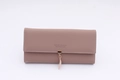 Close-up of contrast stitching, gold buckle and leaf charm on mauve long wallet - Dust Rose