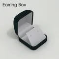Detail of black velvet jewelry box for earrings featuring a white slanted inner insert card - Green Exterior/White Interior/White Insert