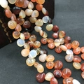 Macro shot of warm-toned agate beads in teardrop shapes for DIY jewelry making - 10mmx12mm / Natural Spotted White Agate
