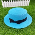 Detailed top view of blue straw boater hat with black ribbon bow on green grass - M / With Bow / Lake Blue