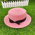 Close-up of pink woven straw sun hat featuring a delicate black ribbon bow detail - M / With Bow / Pink