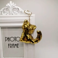 Cute golden sequin cat keychain accessory hanging on a white decorative frame - Gold
