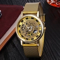 Men's gold quartz watch with hollow dial and mesh band on a wooden business setting - Gold