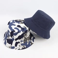 Détail d'un chapeau bob réversible montrant le côté bleu marine et le motif camouflage - Bleu et Blanc