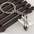 Close-up of a silver fighter jet metal keychain on a dark wooden background - Large Transport Aircraft Model (Aircraft 16)