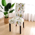 Stretch chair cover with colorful floral pattern on dark wood chair in bright dining room - Spring Vibes