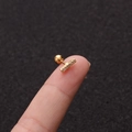 Makroaufnahme eines winzigen 16G Gold-Ohrsteckers mit Zirkon auf einer Fingerspitze - Balken-Stil (No.15 Gold) / 1.2x6mm (Stabdicke x Länge)