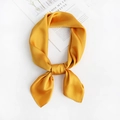 Detail of yellow silk satin neck scarf tied in a knot on a white minimalist background - Yellow