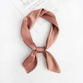 Close-up of pink square silk scarf tied in a bow knot on a minimalist background - Bean Paste Red