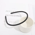 Elegant thin black headband with shimmering rhinestones on a minimalist white desk - Black