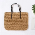 Grand sac cabas de plage en paille avec anses en cuir marron foncé sur fond d'été - Fauve