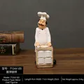 Vintage resin chef figurine holding a wooden cart with white plates for kitchen decor - Pastry Chef