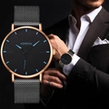 Detail of a Geneva men's watch with black mesh strap and blue markers in a business setting - Black Band Rose Gold Case Blue Dial