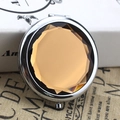 Silver metal folding makeup mirror featuring a large amber faceted crystal surface - Crystal Brown