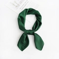 Detail view of dark green silk scarf tied in a decorative knot on a white background - Green