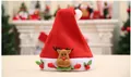 Détail d'un bonnet de Noël festif rouge avec un joli motif de renne en peluche 3D - Enfants Mains en l'air Renne