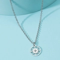 Close-up of compass pendant with hollow design on stainless steel necklace - Compass / Steel