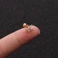 Makroaufnahme eines goldenen Blumenohrrings mit Zirkonia, gehalten an Fingerspitzen - Kleine Blume Gold Stil (No.12 Gold) / 1.2x6mm (Stabdicke x Länge)