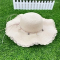 Chapeau de soleil en paille beige à large bord avec perles grises sur l'herbe - M (56-58cm) / Style Ondulé Beige