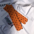Detail of orange cotton Tabi socks with black numeric pattern on a minimalist background - Orange