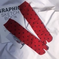 Flat lay of red Tabi split-toe socks with black numbers on a white fabric background - Red