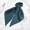 Close-up of elegant dark green satin scrunchie with long ribbons and pearl accents - Dark Green