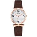 Détail du boîtier en or rose avec cadran blanc et bracelet en cuir marron sur montre femme - Café