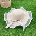 Beige wide brim woven straw sun hat with grey lace trim and a decorative ribbon bow - Beige
