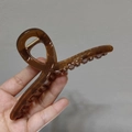 Detail of amber large claw clip with transparent brown finish and metal spring - Caramel