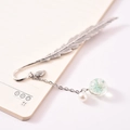 Silver feather metal bookmark with a dried flower glass ball and pearl on an open notebook - Light Blue Gypsophila