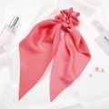 Detailed view of pink satin bow scrunchie with long ribbons on white silk background - Pink