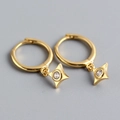 Vue macro de boucles d'oreilles créoles dorées avec pendentifs étoiles sertis de diamants - Argent 925 / Or (1 Paire)