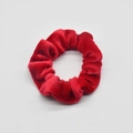 Detail shot of bright red velvet scrunchie showing soft texture and pleated design - Bright Red