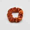 Detailed view of the ribbed corduroy texture and elastic band of this brown hair scrunchie - Caramel color