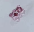 Broche de osito de goma de resina púrpura sobre una superficie blanca reflectante - Rosa Claro Transparente