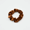 Detailed view of the soft velvet texture and pleats on a brown elastic scrunchie - Brown