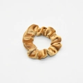 Detailed view of the golden velvet scrunchie showing plush fabric texture and pleats - Gold