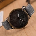 Dettaglio dell'orologio vintage in bronzo con cinturino in denim grigio su legno - Grigio
