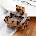 Macro detail of tortoiseshell acetate hair claw clip on a stylish marble background - 7145-1 Creamy Tortoise
