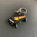 Cartoon grand piano keychain made of black PVC soft rubber with white keys - Piano