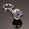 Macro shot of double-sided glass moon keychain with nebula galaxy pattern on black surface - Mercury